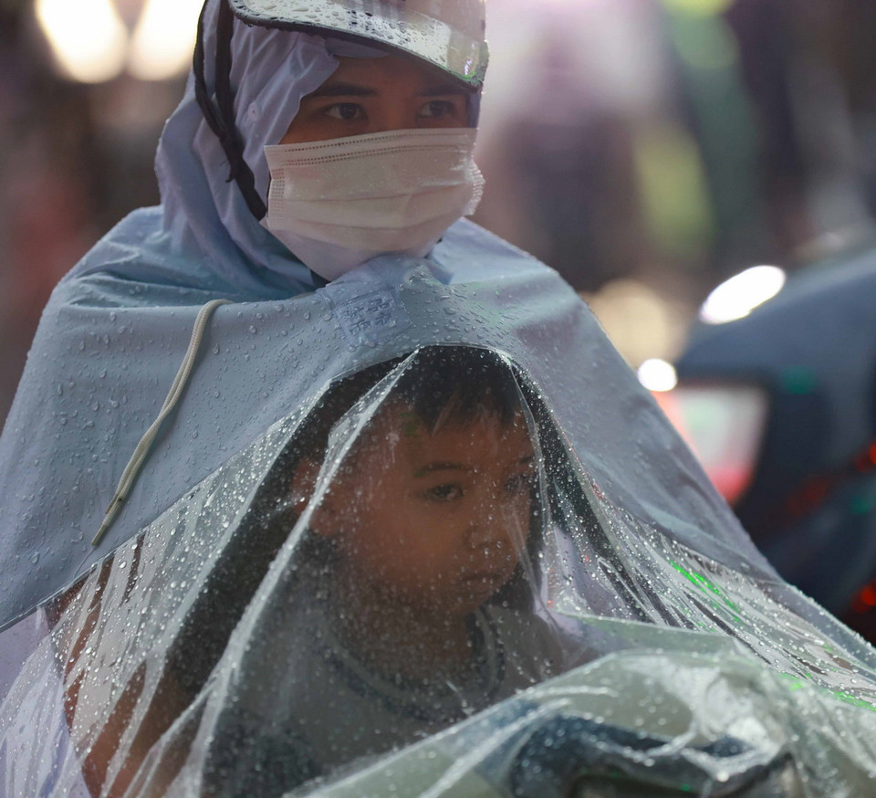 Người dân đội mưa di chuyển khó khăn. (Ảnh: Thanh Tùng/TTXVN)