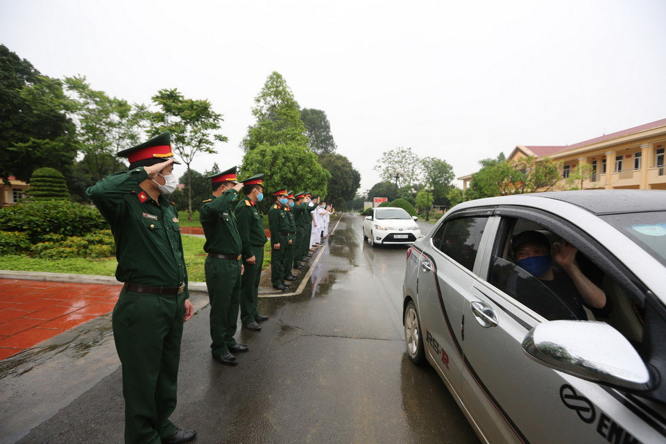 Các cán bộ, chiến sỹ quân y Trung đoàn 58 chào tạm biệt các công dân đã hoàn thành thời gian cách ly trở về địa phương. (Ảnh: Dương Giang/TTXVN)