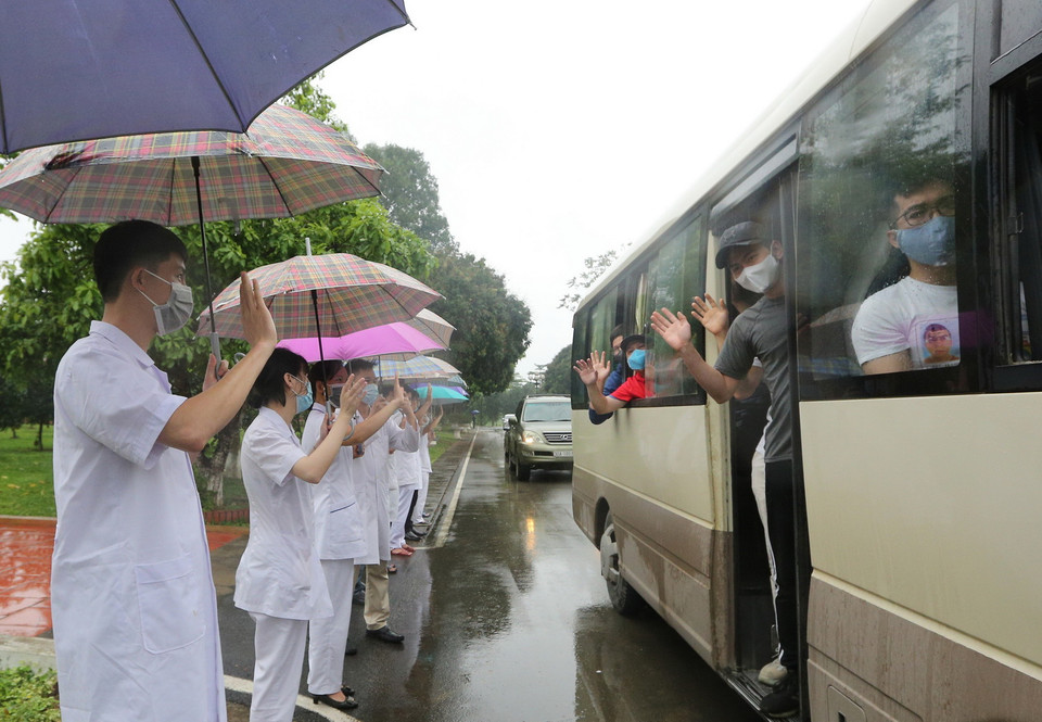 Các cán bộ, chiến sỹ quân y Trung đoàn 58 chào tạm biệt các công dân đã hoàn thành thời gian cách ly trở về địa phương. (Ảnh: Dương Giang/TTXVN)
