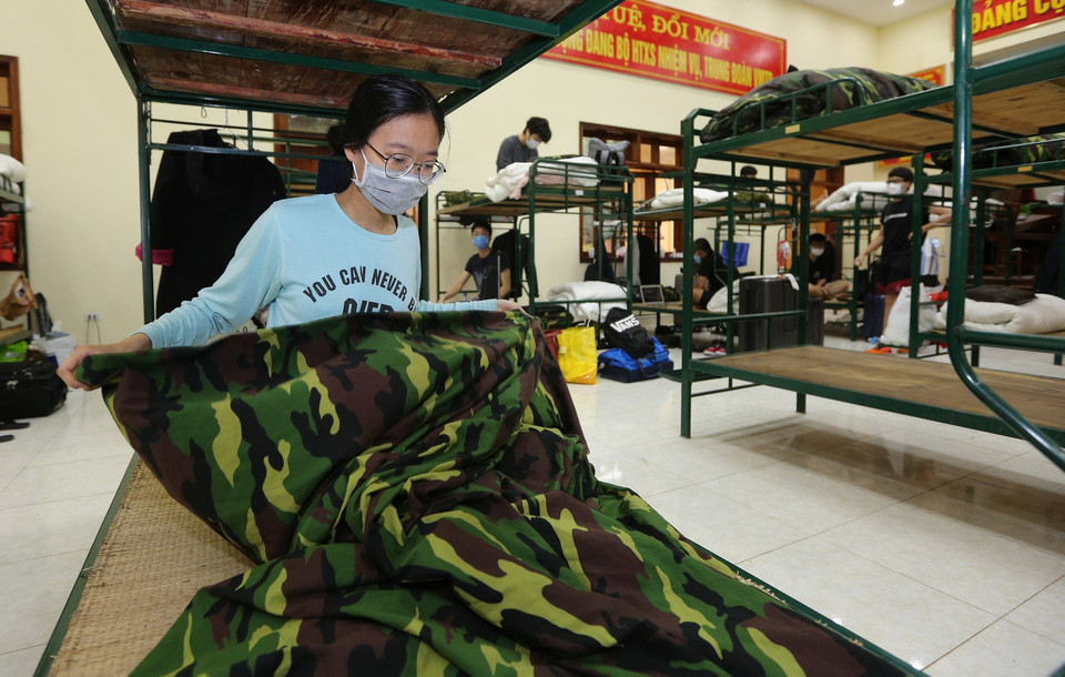 Các công dân sắp xếp tư trang chuẩn bị rời Trung đoàn 58 sau khi hoàn thành thời gian cách ly. (Ảnh: Dương Giang/TTXVN)