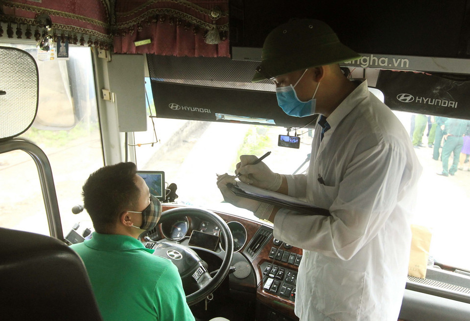 Lực lượng liên ngành tiến hành ghi chép lộ trình tham gia giao thông của các phương tiện trước khi vào thành phố. (Ảnh: An Đăng/TTXVN)