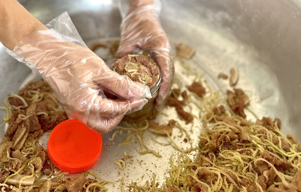 Cho thịt, đu đủ được nén chặt trong lọ để trong 3-5 ngày. Thịt chua đu đủ ăn kèm với lá sung, lá mơ, lá ổi... chấm kèm với tương ớt… tạo nên món ăn đặc biệt, độc và lạ. (Ảnh: Tạ Toàn/TTXVN)