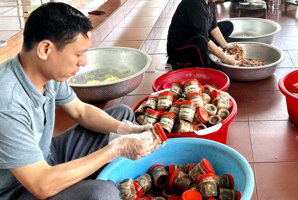 Dán nhãn cho món thịt chua đu đủ. (Ảnh: Tạ Toàn/TTXVN)