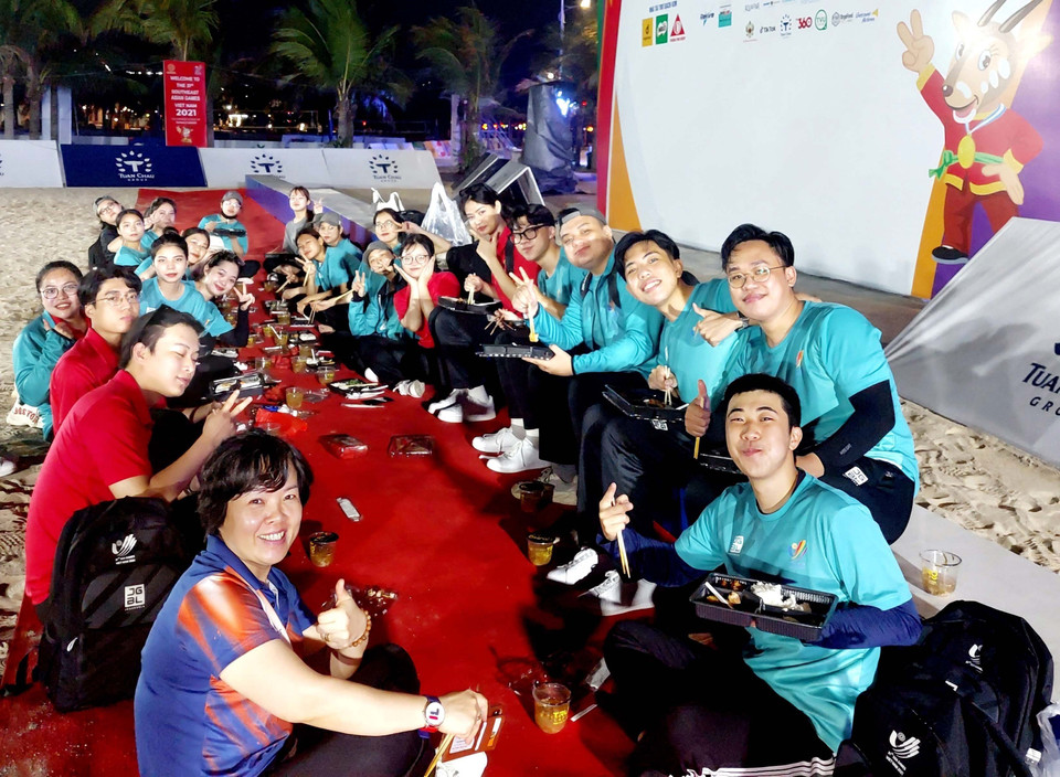 Bữa tối vui vẻ của đội tình nguyện viên ngay trên bãi cát sau khi kết thúc các trận thi đấu bóng ném bãi biển tại khu du lịch Tuần Châu. (Ảnh: Thanh Vân/TTXVN)