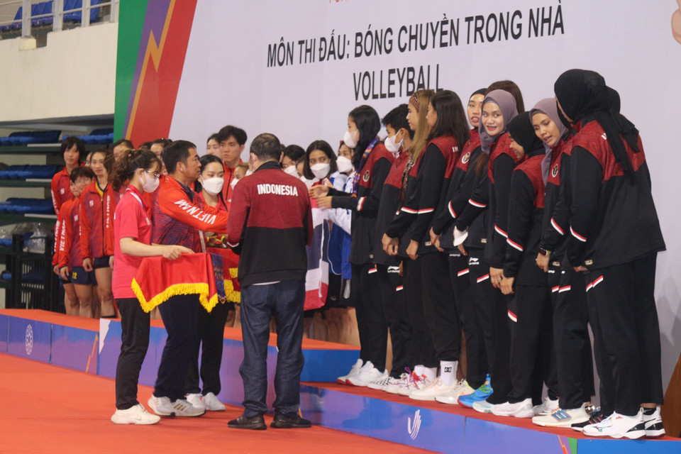 Các tình nguyện viên nữ hỗ trợ Ban tổ chức SEA Games trao huy chương cho các đoàn. (Ảnh: Thanh Vân/TTXVN)