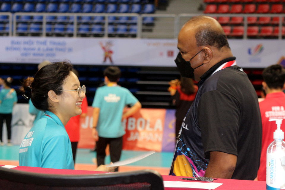 Các tình nguyện vên trò chuyện vui vẻ, tự tin bằng ngôn ngữ nước ngoài với thành viên đoàn quan chức trọng tài sau trận đấu. (Ảnh: Thanh Vân/TTXVN)