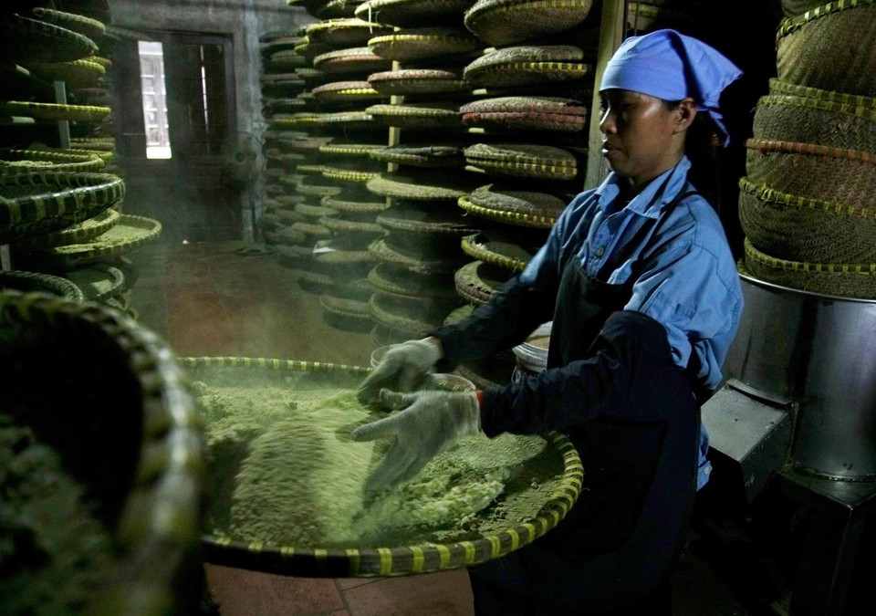 Công đoạn đảo cơm nếp để mốc lên đều. (Ảnh: Phạm Kiên/TTXVN)