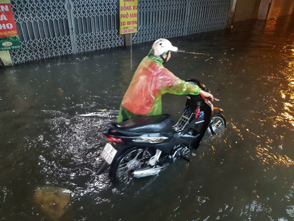 Người dân dắt bộ xe về nhà trên phố Bùi Xương Trạch, quận Thanh Xuân. (Ảnh: Phan Tuấn Anh/TTXVN)