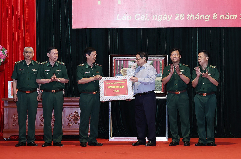Thủ tướng Phạm Minh Chính tặng quà cho cán bộ, chiến sỹ Bộ Chỉ huy Bộ đội Biên phòng tỉnh Lào Cai. (Ảnh: Dương Giang/TTXVN)