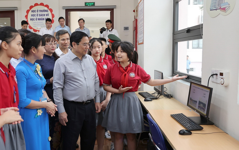 Thủ tướng Phạm Minh Chính nghe học sinh giới thiệu về cơ sở vật chất cụm liên trường học thành phố Lào Cai. (Ảnh: Dương Giang/TTXVN)