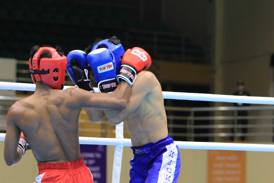 Vận động viên Kham Khlaneang (đội Campuchia, đỏ) và vận động viên Masdor Mohammad-Rifdean (đội Malaysia, xanh) ở nội dung Full Contact hạng cân dưới 51kg với tỷ số 0-3. (Ảnh: Thái Hùng/TTXVN)