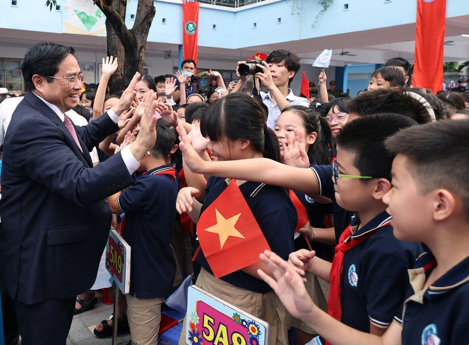 Học sinh Trường Tiểu học Đoàn Thị Điểm chào đón Thủ tướng Phạm Minh Chính. (Ảnh: Dương Giang/TTXVN)