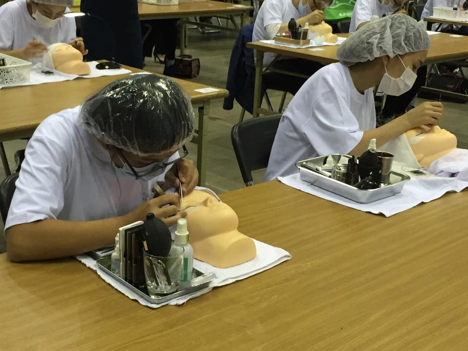 Kỹ tthuật viên tiến hành cấy mi trên manơcanh. (Ảnh: Khánh Ly/Vietnam+)