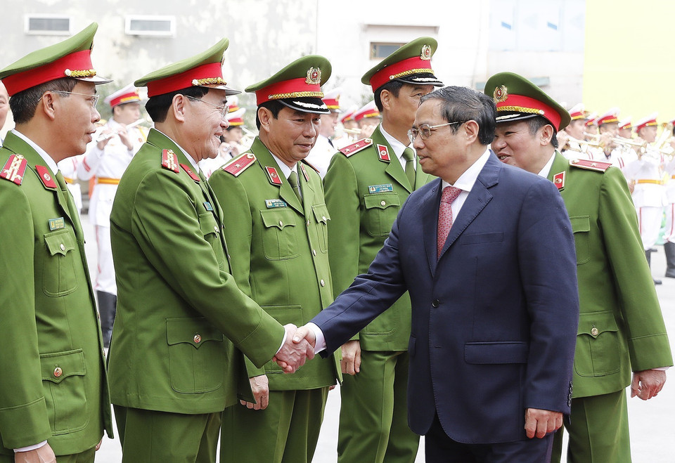 Thủ tướng Phạm Minh Chính với lãnh đạo Cục Cảnh sát điều tra tội phạm về ma túy. (Ảnh: Dương Giang/TTXVN)