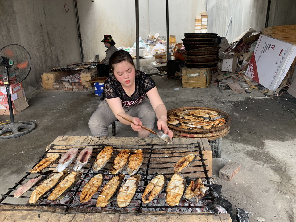 Trong quá trình nướng, cần phải giữ lửa than đượm đều để cá chín từ từ, không bị cháy. Vào những ngày này, khách hàng tìm về đây để đặt mua cá nướng về làm quà Tết cho gia đình, bạn bè, người thân, đông hơn.(Ảnh: Khiếu Tư/TTXVN)