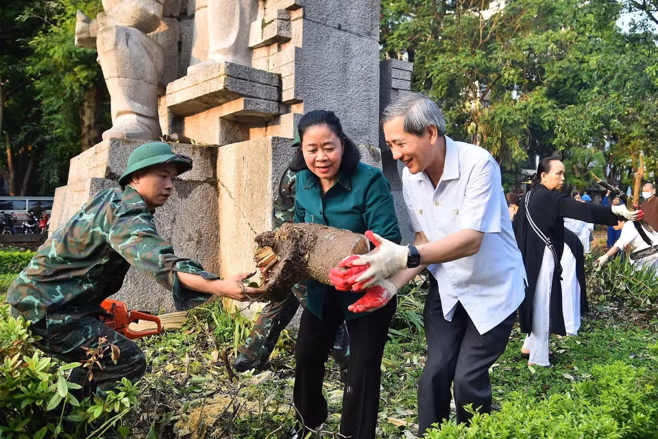 Bí thư Thành ủy Hà Nội Bùi Thị Minh Hoài tham gia vệ sinh môi trường cùng người dân tại Vườn hoa Vạn Xuân. (Ảnh: TTXVN phát)