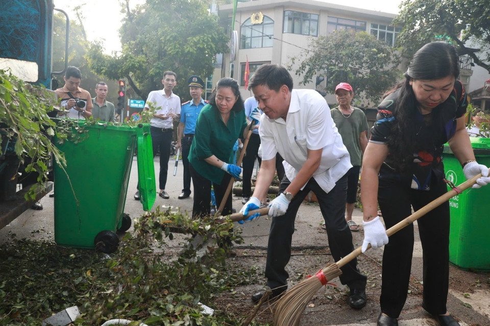 Bí thư Thành ủy Hà Nội Bùi Thị Minh Hoài tham gia vệ sinh môi trường cùng người dân tại phố Trần Hưng Đạo, quận Hoàn Kiếm. (Ảnh: TTXVN phát)