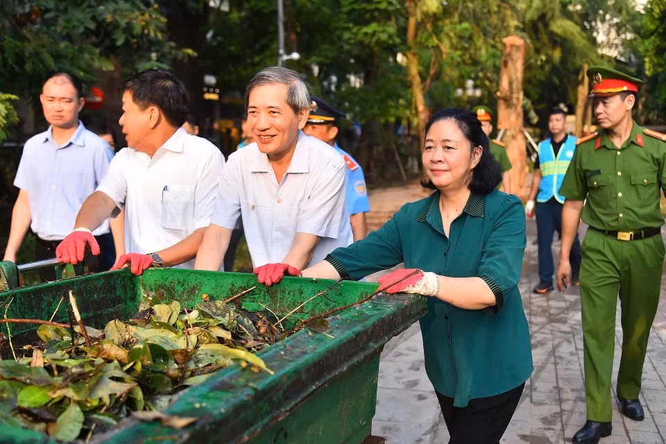 Bí thư Thành ủy Hà Nội Bùi Thị Minh Hoài tham gia vệ sinh môi trường cùng người dân tại Vườn hoa Vạn Xuân. (Ảnh: TTXVN phát)