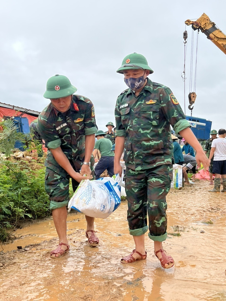 Hàng trăm người đang tích cực gia cố đoạn đê sông Giăng trước nguy cơ bị tràn nước. (Ảnh: Tá Chuyên/TTXVN)