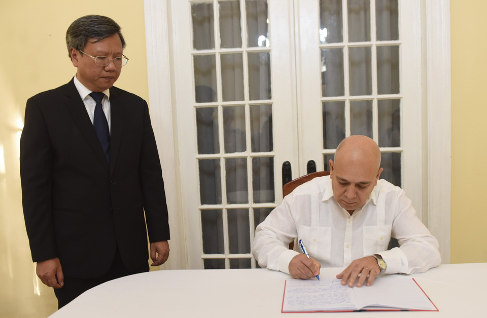 Ủy viên Bộ Chính trị, Thường trực Ban Bí thư, Trưởng Ban Tổ chức trung ương Đảng Cộng sản Cuba Roberto Morales Ojeda ghi sổ tang. (Ảnh: Việt Hùng/TTXVN)