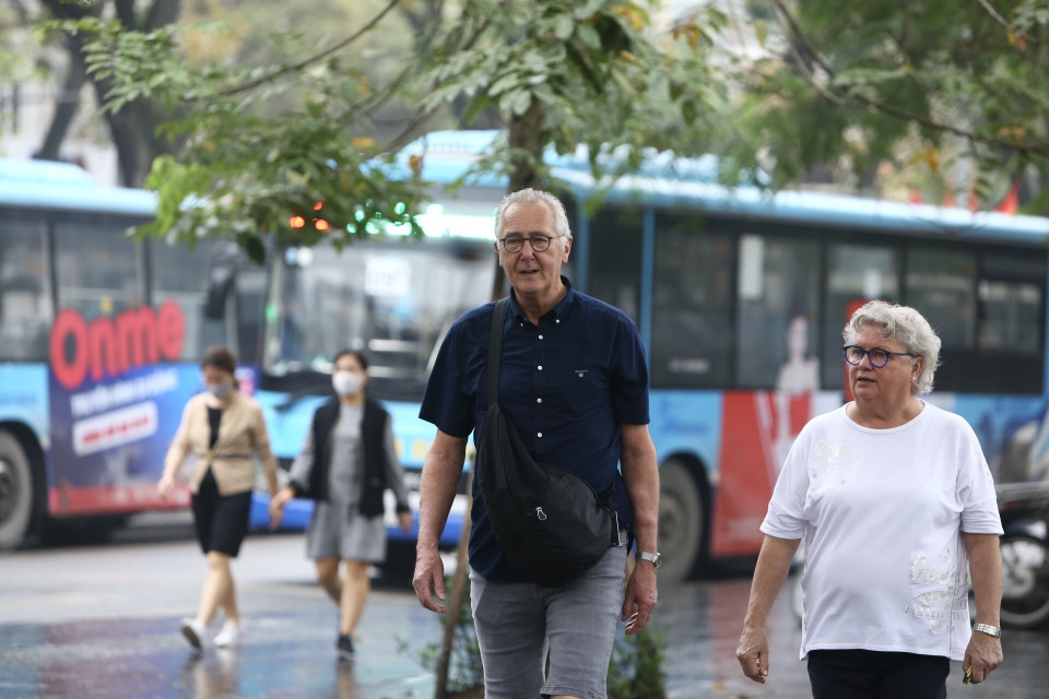 Nhiều du khách thản nhiên đi dạo quanh hồ Hoàn Kiếm mà không đeo khẩu trang. (Ảnh: Minh Quyết/TTXVN)