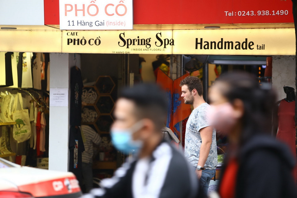 Du khách thản nhiên đi tham quan phố cổ mà không đeo khẩu trang. (Ảnh: Minh Quyết/TTXVN)