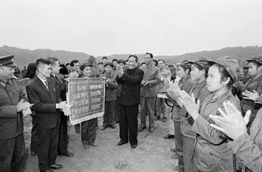 Đồng chí Lê Duẩn tặng Ủy ban Trung ương Mặt trận Lào yêu nước bức trướng thêu lời của Chủ tịch Hồ Chí Minh: “Việt – Lào hai nước chúng ta/Tình sâu hơn nước Hồng Hà, Cửu Long” trong chuyến thăm Vùng giải phóng Lào từ ngày 2-6/11/1973. (Ảnh: TTXVN)