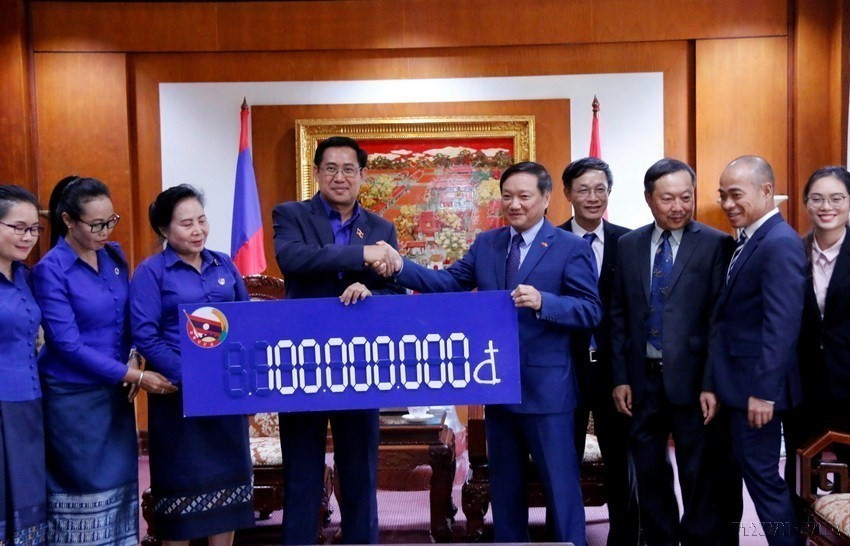 Bí thư Trung ương Đoàn Thanh niên NDCM Lào Alounsay Sounnalath trao cho Đại sứ Việt Nam Nguyễn Bá Hùng số tiền 100.000 triệu đồng hỗ trợ đồng bào miền Trung Việt Nam khắc phục hậu quả mưa bão (Vientiane, 6/11/2020). (Ảnh: Phạm Kiên/TTXVN)