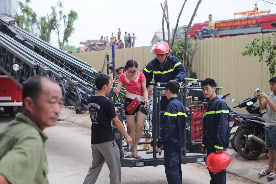 Một nạn nhân bị mắc kẹt trên tầng cao được xe thang giải cứu, đưa xuống đất an toàn. (Ảnh: PV/Vietnam+)