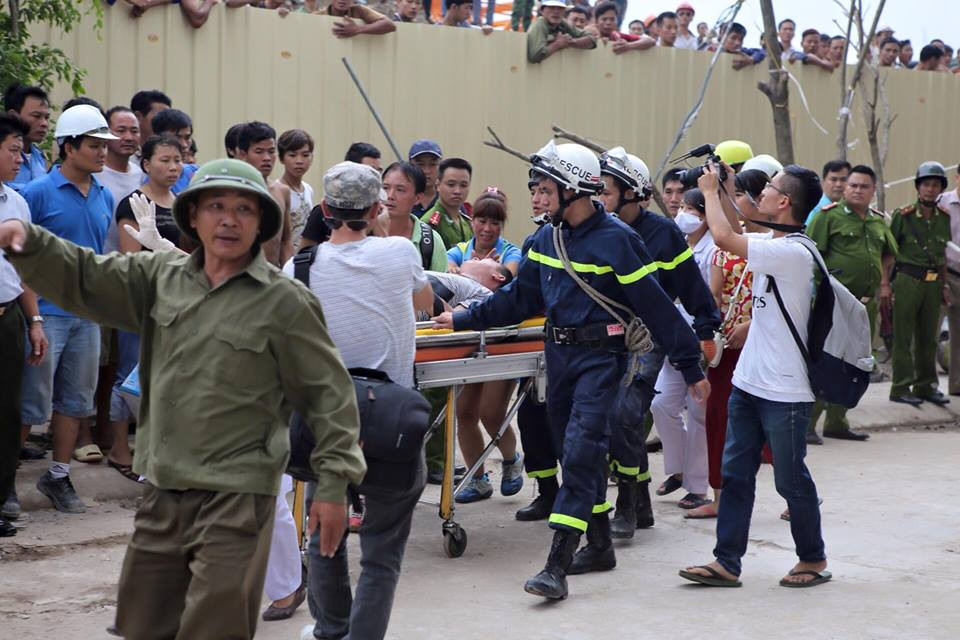 Nạn nhân đầu tiên được giải cứu và đưa đi cấp cứu. Hiện chưa rõ tình trạng sức khỏe của người này. (Ảnh: PV/Vietnam+)