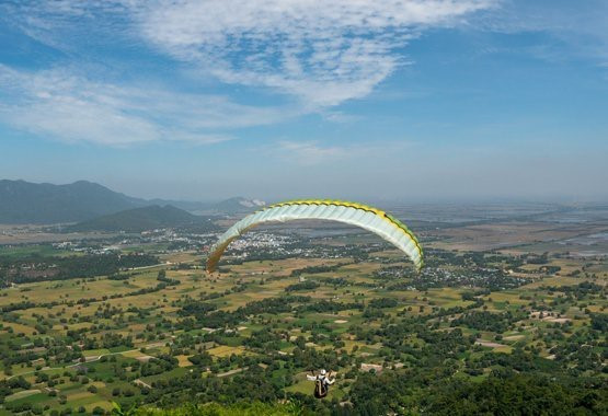 Chương trình biểu diễn dù lượn thể thao Bay trên Phụng Hoàng Sơn thu hút hàng nghìn du khách trong và ngoài tỉnh đến tham dự. (Ảnh: Công Mạo/TTXVN)
