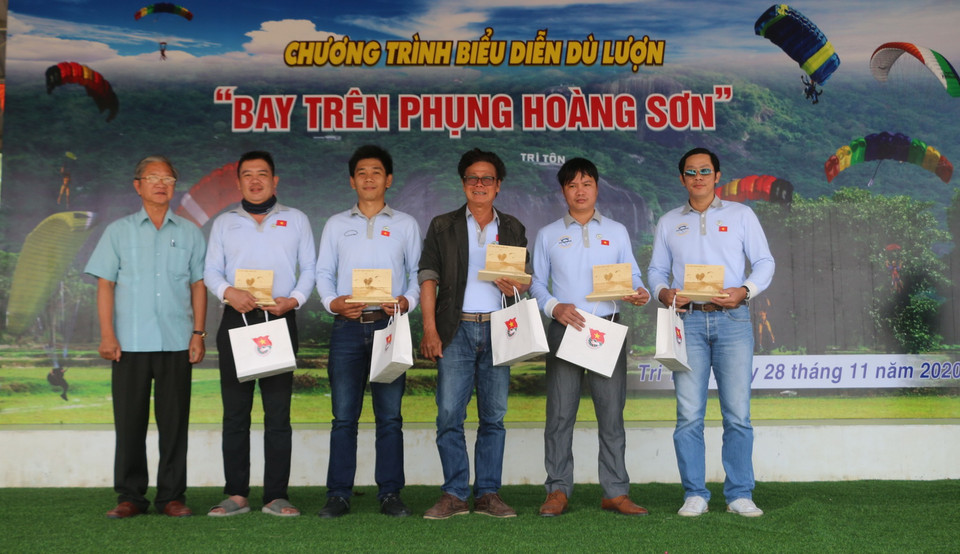Bí thư, Chủ tịch UBND huyện Tri Tôn Cao Quang Liêm (bên trái) tặng quà lưu niệm cho đại diện Câu lạc bộ Dù lượn Thành phố Hồ Chí Minh. (Ảnh: Công Mạo/TTXVN)