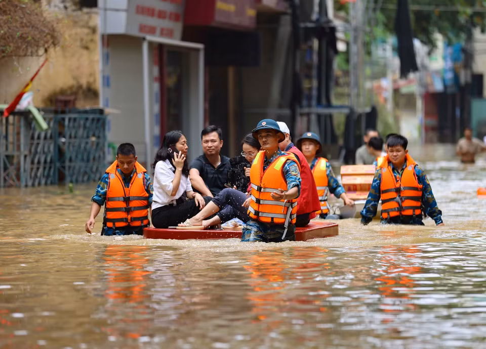 Quân đội huy động người và phương tiện giúp dân di chuyển ra khỏi vùng ngập. (Ảnh: Thanh Tùng/TTXVN)