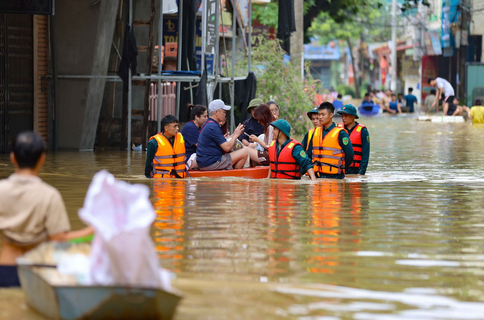 Lực lượng quân đội và dân quân tự vệ xã Bát Tràng giúp người dân di chuyển và tiếp tế nhu yếu phẩm. (Ảnh: Thanh Tùng/TTXVN)