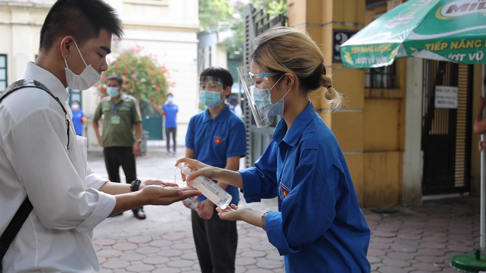 Thí sinh được sát khuẩn tay trước khi vào địa điểm thi (Ảnh: Hoàng Đạt/Vietnam+)