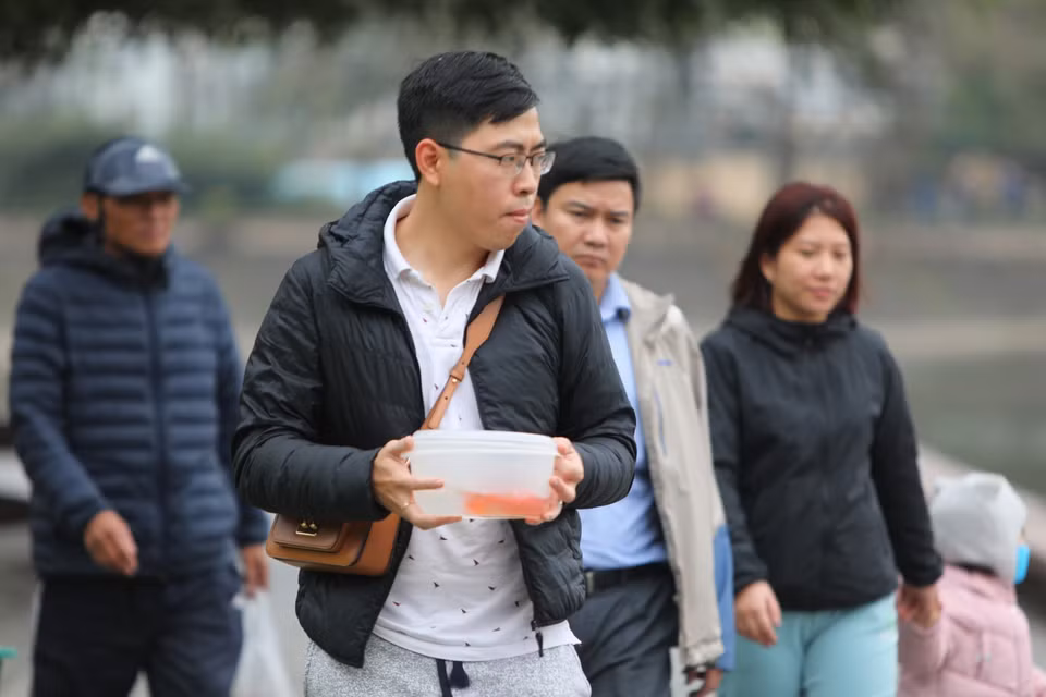 Người Việt thả cá chép để tiễn đưa ông Táo về trời, cầu mong năm mới bình an, thuận lợi. (Ảnh: Thành Đạt/TTXVN)