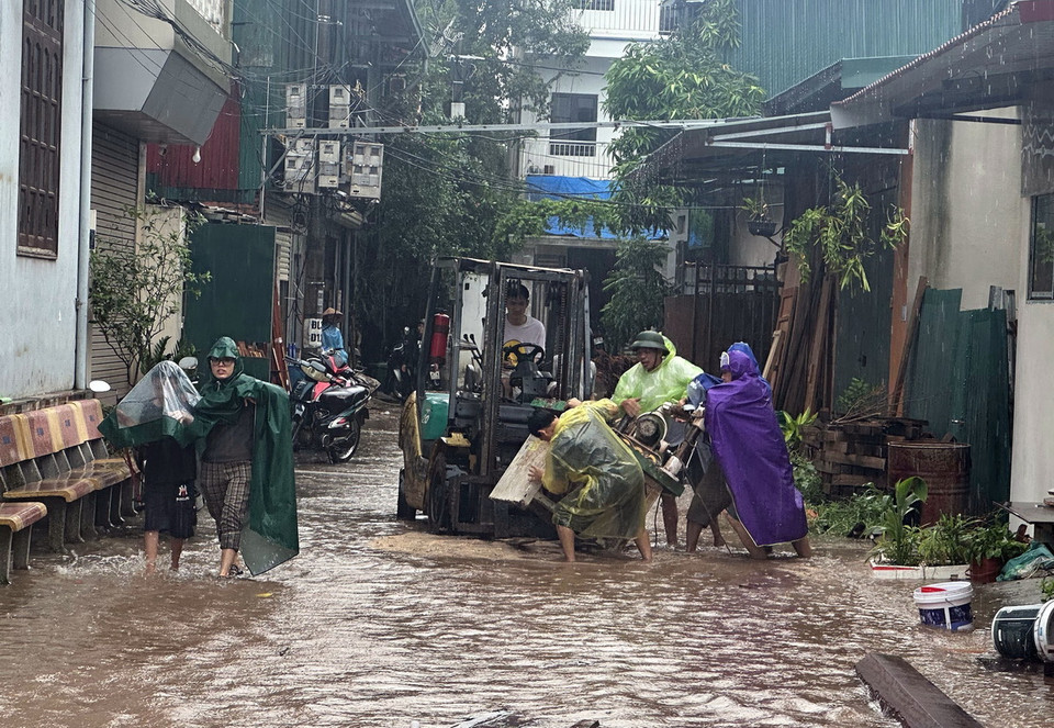 Người dân xã Liên Hồng (huyện Đan Phượng) di dời tài sản lên khu vực địa hình cao (ảnh chụp lúc 11h58). (Ảnh: Huy Hùng/TTXVN)