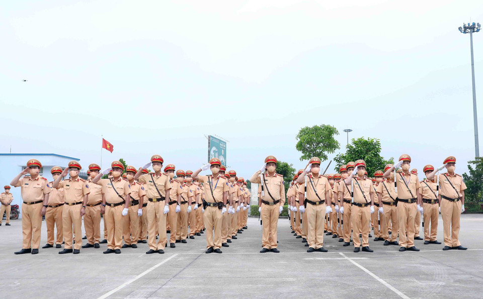 Cán bộ, chiến sỹ Cảnh sát giao thông thực hiện nghi thức chào cờ tại buổi lễ. (Ảnh: Phạm Kiên/TTXVN)