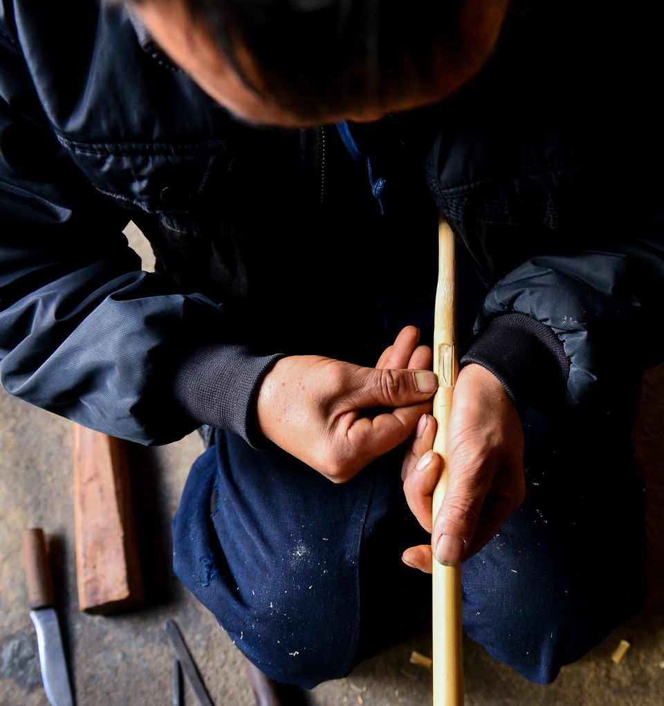  Công đoạn khoét lỗ trên thân cây trúc để gắn lưỡi đồng tạo lên âm thanh. (Ảnh: Nam Thái/TTXVN)