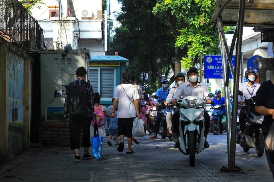 Người đi bộ xen lẫn xe máy khi đi trên vỉa hè đoạn qua nút giao Ngã Tư Sở. (Ảnh: Tuấn Anh/TTXVN)