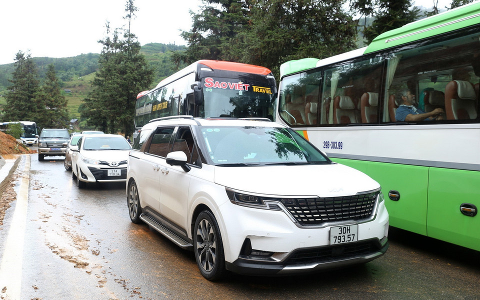 Các phương tiện tham gia giao thông trên Quốc lộ 4D đoạn qua địa phận phường Hàm Rồng, thị xã Sa Pa, tỉnh Lào Cai, không thể lưu thông do sạt lở đất đá xuống lòng đường. (Ảnh: Quốc Khánh/TTXVN)