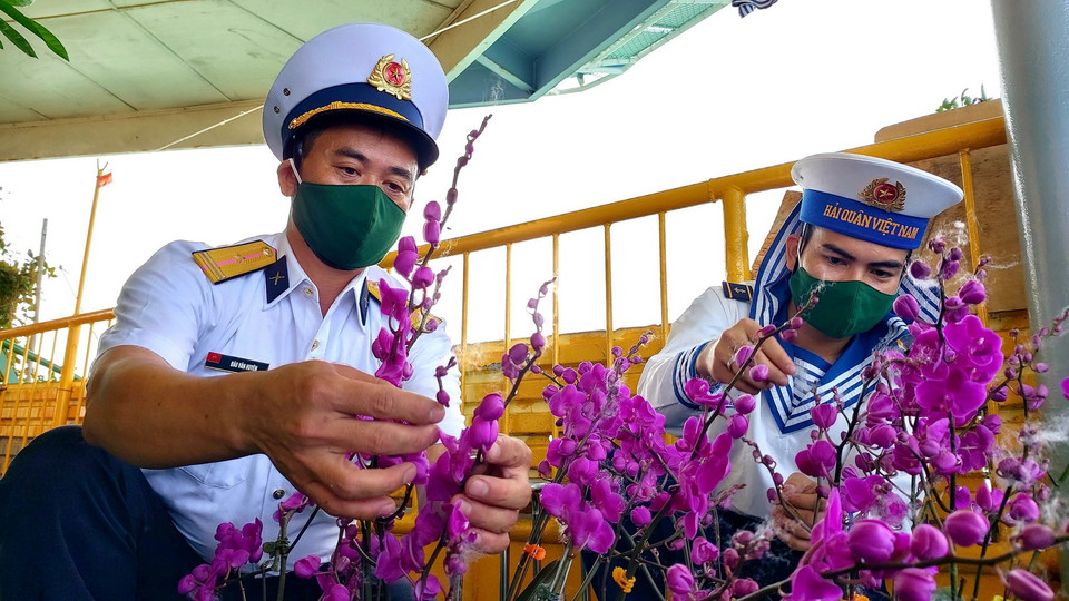 Các chiến sỹ Nhà giàn DK1/10 sửa soạn lại các giò hoa lan được người dân đất liền gửi tặng. (Ảnh: Thu Hiền/TTXVN)