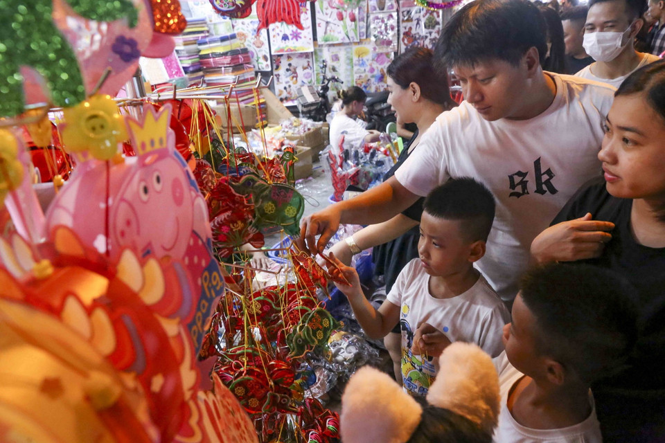 Các em nhỏ lựa chọn những món đồ chơi truyền thống. (Ảnh: Tuấn Đức/TTXVN)