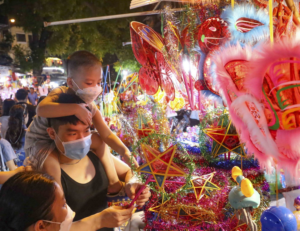 Các em nhỏ chọn mua những món đồ chơi truyền thống. (Ảnh: Tuấn Đức/TTXVN)