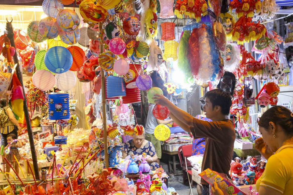 Các bạn trẻ chọn mua các món đồ chơi truyền thống. (Ảnh: Tuấn Đức/TTXVN)