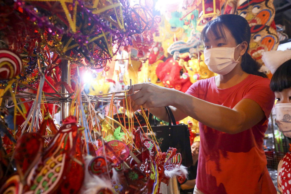 Du khách chọn mua các món đồ chơi truyền thống. (Ảnh: Tuấn Đức/TTXVN)