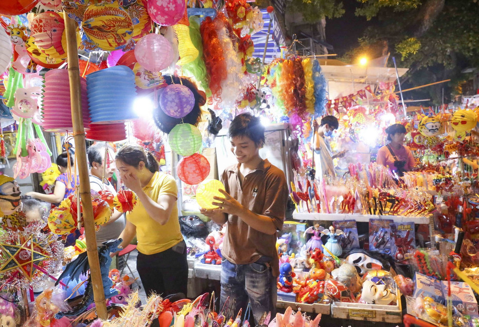 Du khách chọn mua các món đồ chơi truyền thống. (Ảnh: Tuấn Đức/TTXVN)