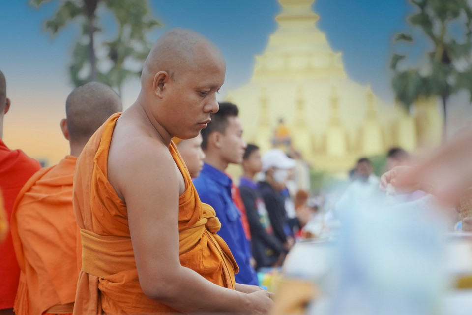 Động tác cầu nguyện trước khi dâng đồ cho các nhà sư. (Ảnh: Đỗ Bá Thành/Vietnam+)