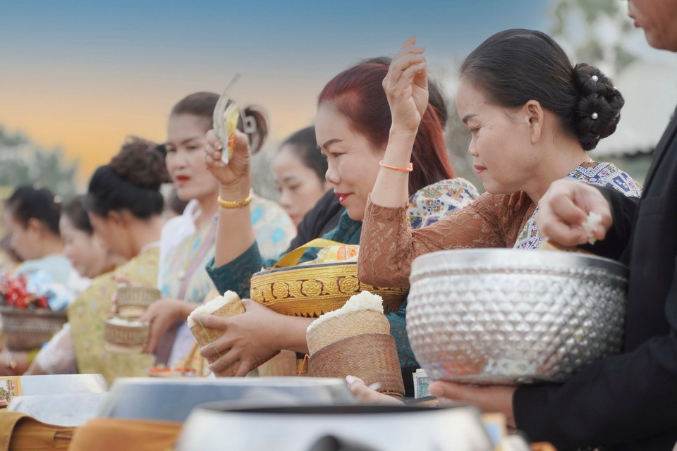 Động tác cầu nguyện trước khi dâng đồ cho các nhà sư. (Ảnh: Đỗ Bá Thành/Vietnam+)