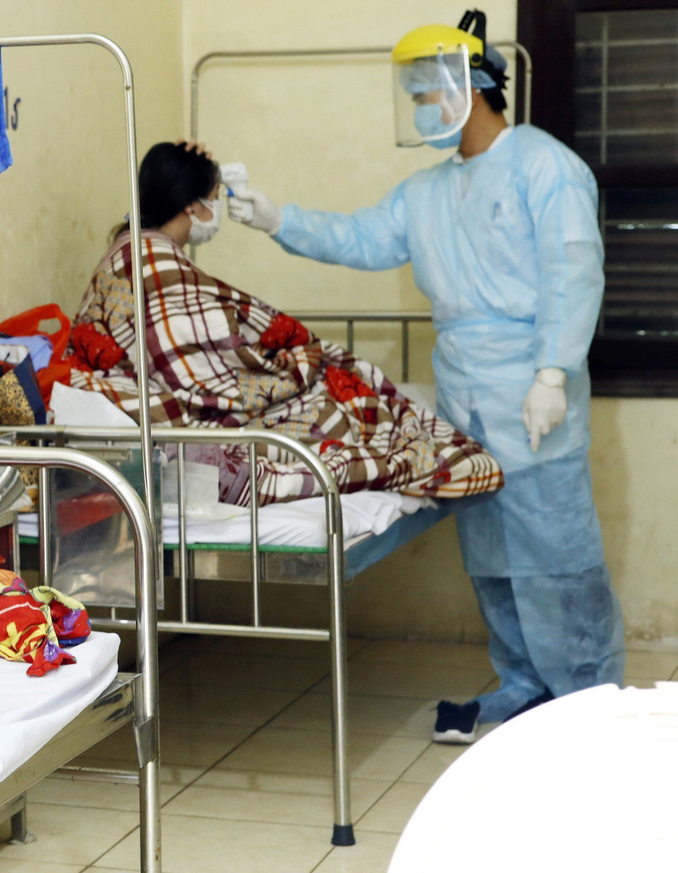 Nhân viên y tế kiểm tra thân nhiệt cho các ca bệnh đang được cách ly theo dõi nCoV tại Trung tâm Y tế Bình Xuyên - ảnh chụp chiều 7/2. (Ảnh: Dương Ngọc/TTXVN)